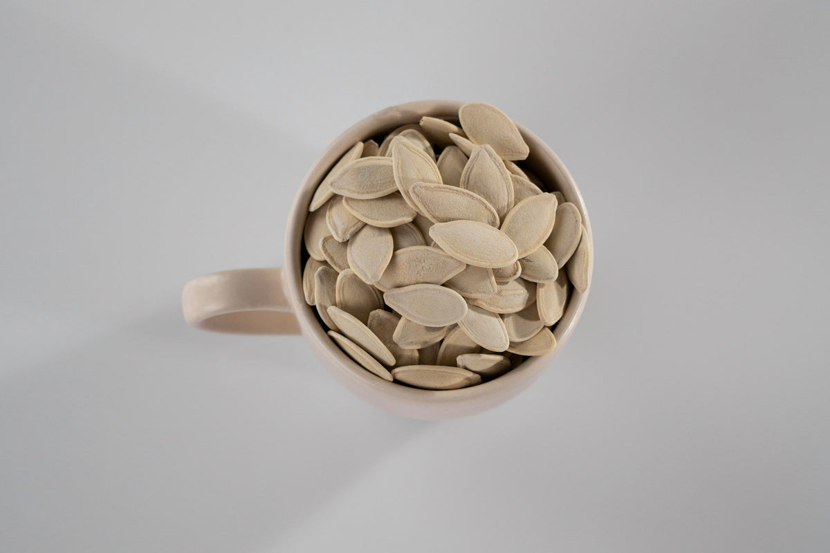 Pestki dyni w ceramicznym kubku – naturalne źródło cynku wspierającego równowagę hormonalną kobiet